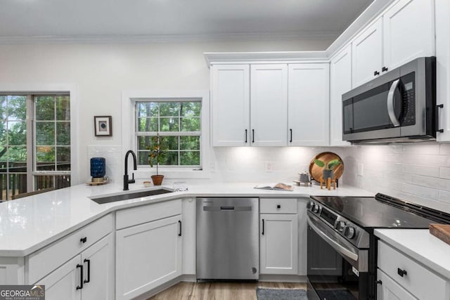 5560 Pilgrim Point Ext, Cumming, GA 30041 - kitchen with appliances with stainless steel finishes, light countertops, white cabinetry, tasteful backsplash, and a peninsula