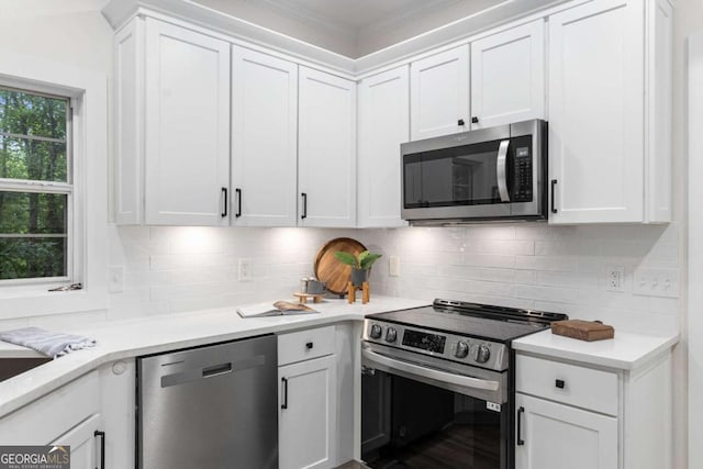5560 Pilgrim Point Ext, Cumming, GA 30041 - kitchen featuring appliances with stainless steel finishes, white cabinets, light countertops, decorative backsplash, and ornamental molding