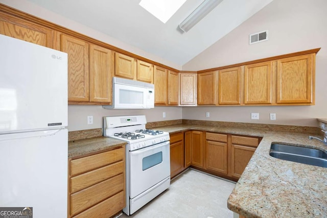 5069 Kathryn Glen Dr, Acworth, GA 30101 - kitchen with white appliances, vaulted ceiling, a skylight, and light stone countertops