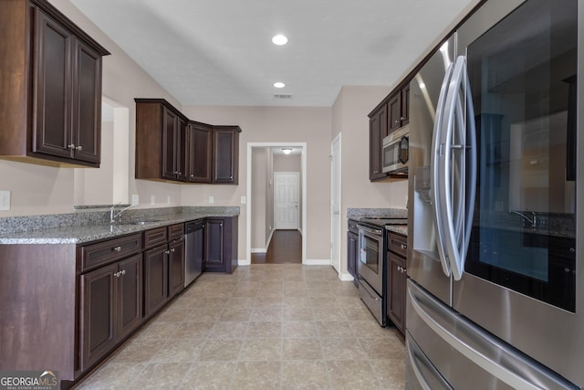 502 Creekside Dr, Lagrange, GA 30240 - kitchen with appliances with stainless steel finishes, dark brown cabinetry, light stone countertops, and recessed lighting