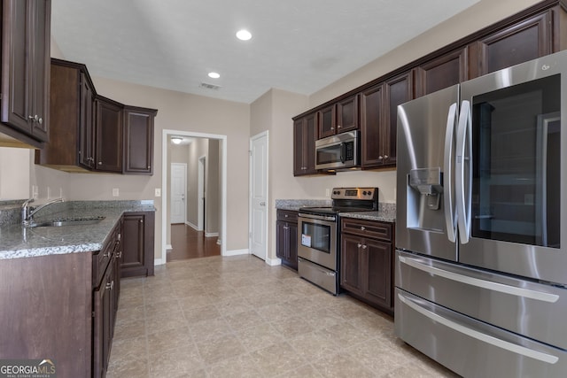 502 Creekside Dr, Lagrange, GA 30240 - kitchen featuring appliances with stainless steel finishes, dark brown cabinetry, light stone counters, and recessed lighting
