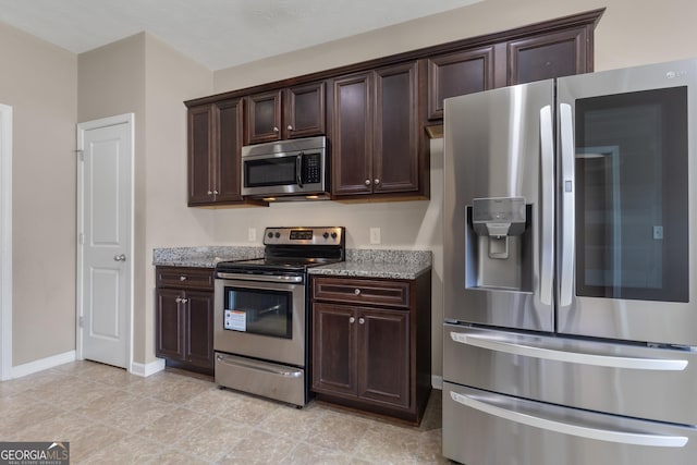 502 Creekside Dr, Lagrange, GA 30240 - kitchen featuring appliances with stainless steel finishes, dark brown cabinetry, and light stone countertops
