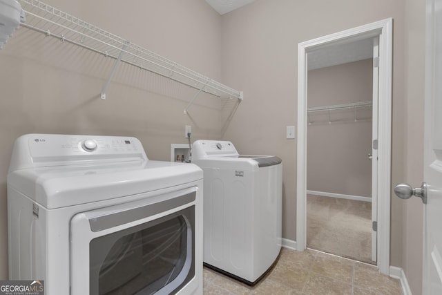 502 Creekside Dr, Lagrange, GA 30240 - washroom with washer and clothes dryer, light tile patterned floors, and light colored carpet