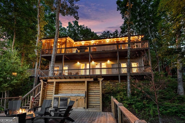 128 Overlake Ct, Morganton, GA 30560 - back of house with a fire pit, stairway, a wooden deck, a sunroom, and a hot tub