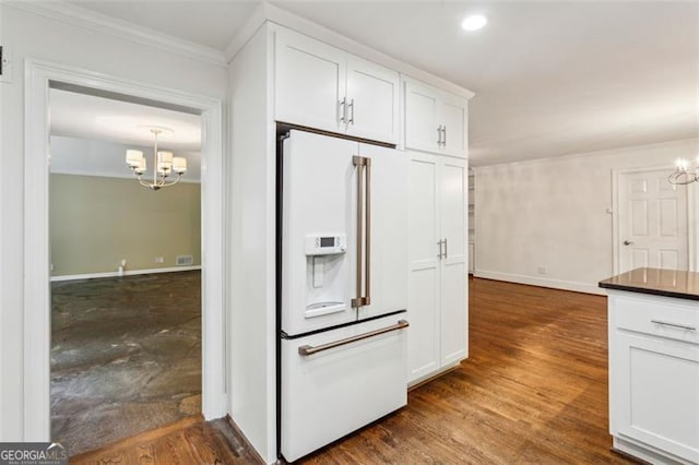 750 Crest Valley Dr NW, Sandy Springs, GA 30327 - kitchen with white refrigerator with ice dispenser, a chandelier, ornamental molding, white cabinetry, and dark countertops
