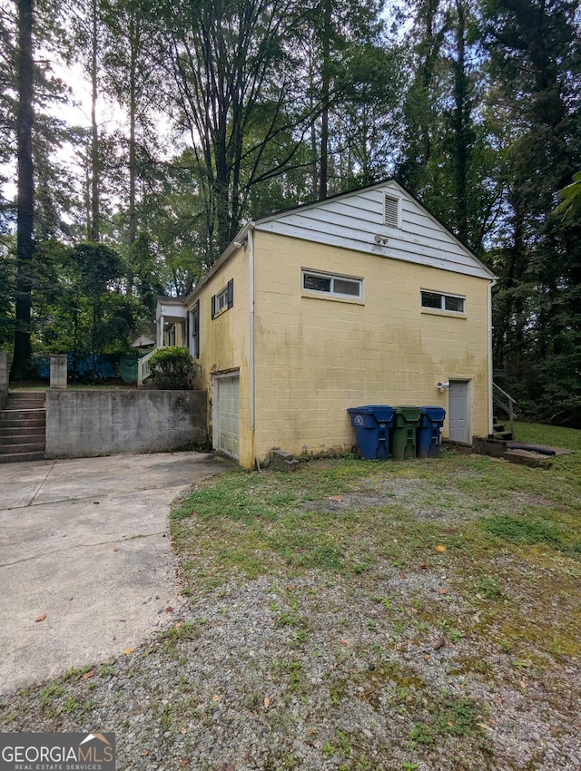 1750 Beechwood Blvd SW, Atlanta, GA 30311 - view of side of home featuring stairway, concrete driveway, concrete block siding, and a garage