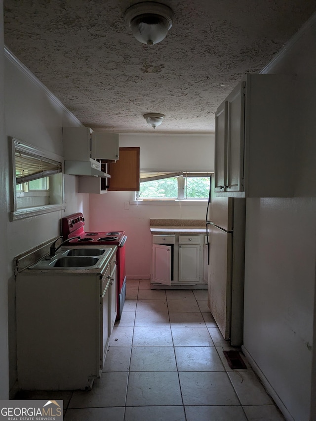 1750 Beechwood Blvd SW, Atlanta, GA 30311 - kitchen featuring extractor fan, freestanding refrigerator, range with electric cooktop, light tile patterned floors, and crown molding