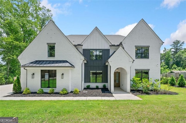 103 Maddox Rd, Buford, GA 30518 - view of front of property with board and batten siding, a standing seam roof, a front lawn, brick siding, and a metal roof