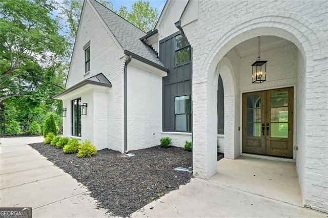 103 Maddox Rd, Buford, GA 30518 - view of exterior entry with french doors, brick siding, and a shingled roof