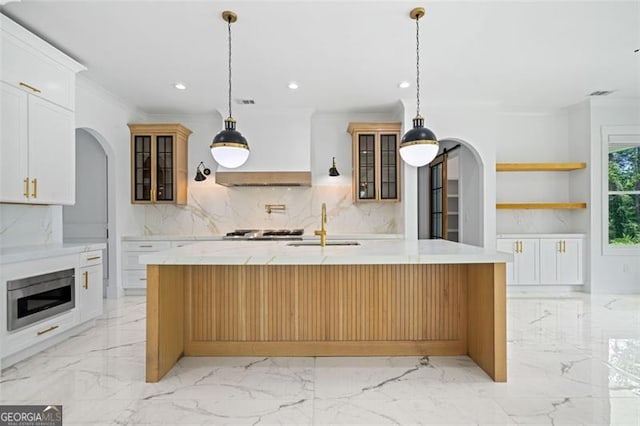 103 Maddox Rd, Buford, GA 30518 - kitchen featuring arched walkways, backsplash, recessed lighting, light marble finish floors, and glass insert cabinets