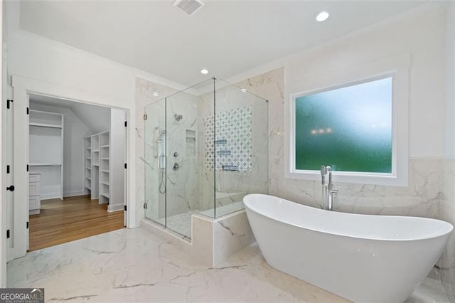 103 Maddox Rd, Buford, GA 30518 - full bathroom with marble tiled floors, a marble finish shower, a soaking tub, a spacious closet, and recessed lighting