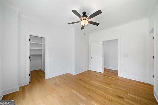 103 Maddox Rd, Buford, GA 30518 - unfurnished bedroom with light wood-type flooring, a walk in closet, a ceiling fan, a closet, and crown molding