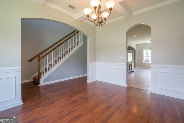 43 NE Yearling Ct, Ludowici, GA 31316 - empty room with wood finished floors, stairway, a chandelier, arched walkways, and wainscoting