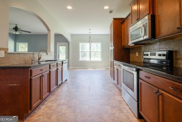 43 NE Yearling Ct, Ludowici, GA 31316 - kitchen with appliances with stainless steel finishes, healthy amount of natural light, decorative backsplash, arched walkways, and recessed lighting