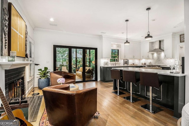 1833 N Rock Springs Rd NE, Atlanta, GA 30324 - living area featuring a warm lit fireplace, ornamental molding, light wood-type flooring, and recessed lighting