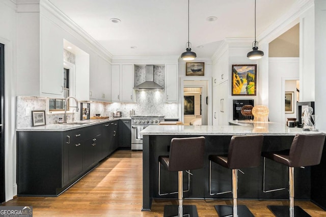 1833 N Rock Springs Rd NE, Atlanta, GA 30324 - kitchen with wall chimney range hood, high end stove, a kitchen breakfast bar, light wood finished floors, and recessed lighting
