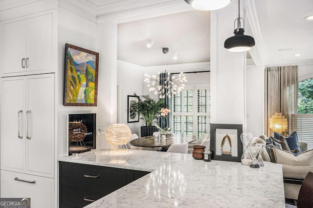 1833 N Rock Springs Rd NE, Atlanta, GA 30324 - kitchen with light stone countertops, white cabinetry, crown molding, and decorative light fixtures