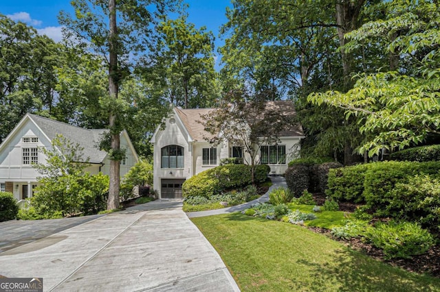 1833 N Rock Springs Rd NE, Atlanta, GA 30324 - tudor home featuring concrete driveway, a garage, a front lawn, and stucco siding