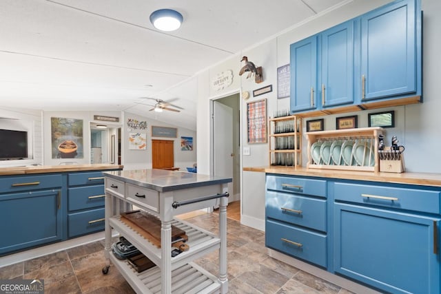 103 Fawn Ct, Eatonton, GA 31024 - kitchen featuring blue cabinetry, vaulted ceiling, stone finish floors, and a ceiling fan
