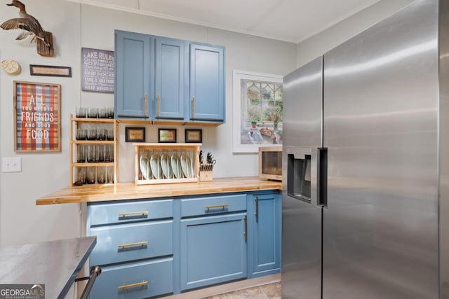 103 Fawn Ct, Eatonton, GA 31024 - kitchen with stainless steel fridge, blue cabinetry, wood counters, and crown molding