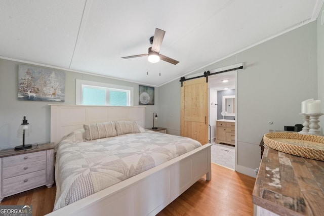 103 Fawn Ct, Eatonton, GA 31024 - bedroom with a barn door, lofted ceiling, light wood-style floors, crown molding, and connected bathroom