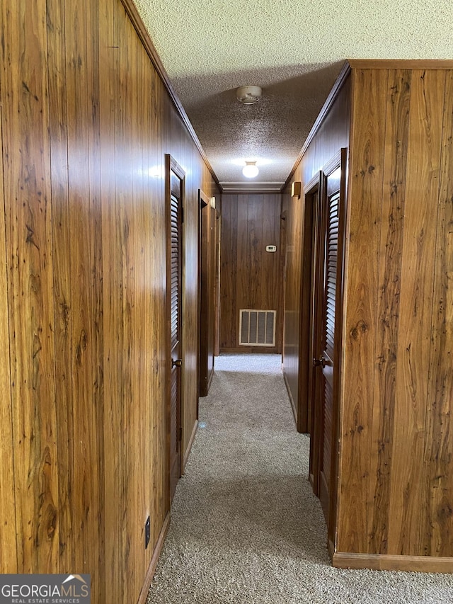6617 18th St SW, Lanett, AL 36863 - hallway featuring ornamental molding, wood walls, carpet, and a textured ceiling