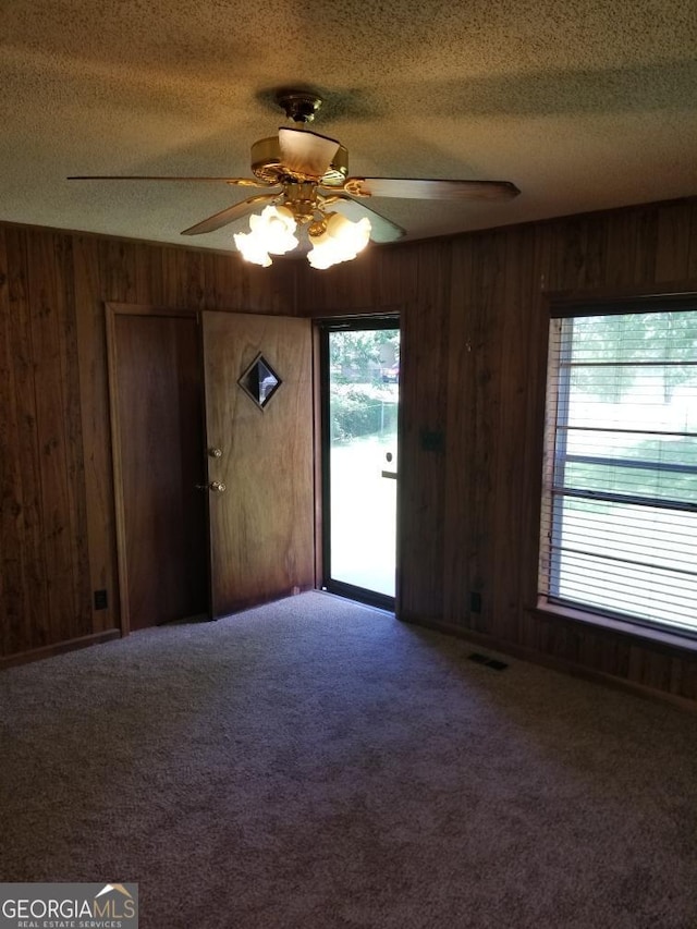 6617 18th St SW, Lanett, AL 36863 - carpeted spare room with wood walls, a ceiling fan, and a textured ceiling