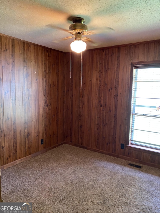 6617 18th St SW, Lanett, AL 36863 - carpeted spare room with a ceiling fan, wooden walls, and a textured ceiling