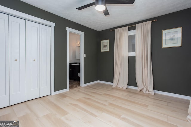 101 Pawnee St, Waleska, GA 30183 - unfurnished bedroom with wood finished floors, a closet, a textured ceiling, ensuite bathroom, and a ceiling fan