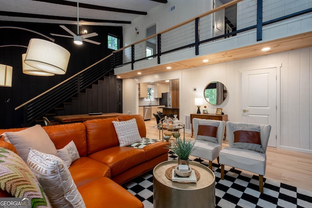 101 Pawnee St, Waleska, GA 30183 - living room with a towering ceiling, stairway, beam ceiling, light wood-style flooring, and wooden walls
