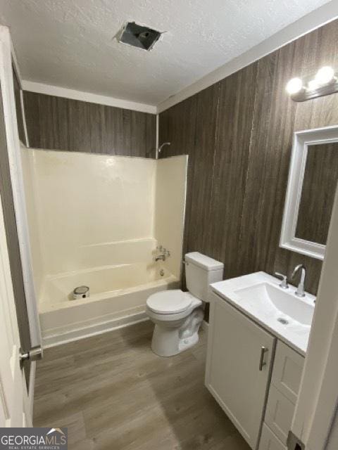 120 Foothill Dr, Dalton, GA 30720 - bathroom with vanity, a textured ceiling, wooden walls, shower / bathtub combination, and wood finished floors