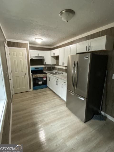 120 Foothill Dr, Dalton, GA 30720 - kitchen featuring appliances with stainless steel finishes, under cabinet range hood, white cabinets, light wood finished floors, and light countertops