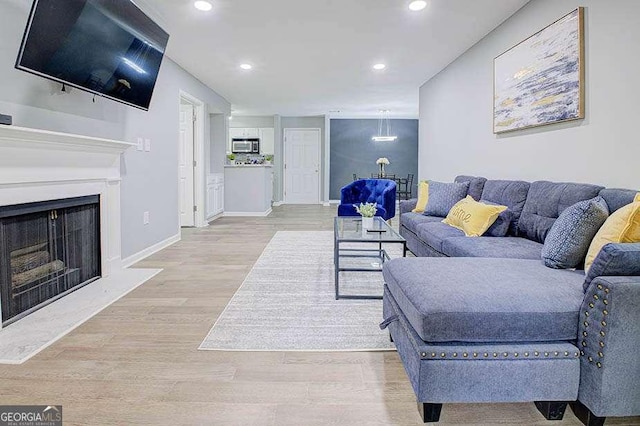 24317 Plantation Dr NE, Atlanta, GA 30324 - living area featuring recessed lighting, wood finished floors, and a fireplace with raised hearth