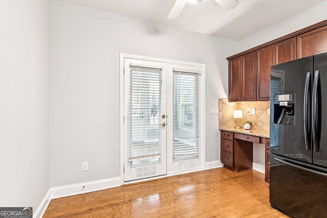 3725 Downing Dr, Cumming, GA 30040 - kitchen with black fridge, light wood-style flooring, backsplash, light stone countertops, and french doors
