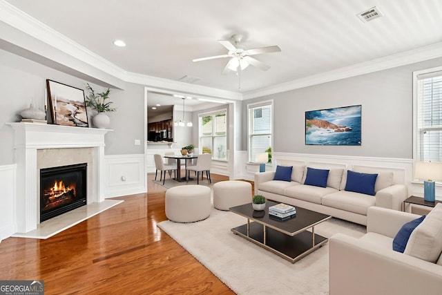 3725 Downing Dr, Cumming, GA 30040 - living room with wood finished floors, a ceiling fan, ornamental molding, a premium fireplace, and wainscoting