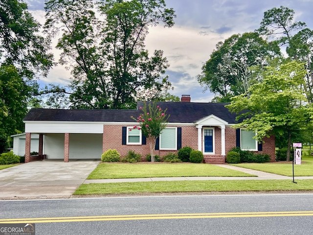 319 N Line St, Dexter, GA 31019 - ranch-style house with concrete driveway, brick siding, a carport, and a front lawn