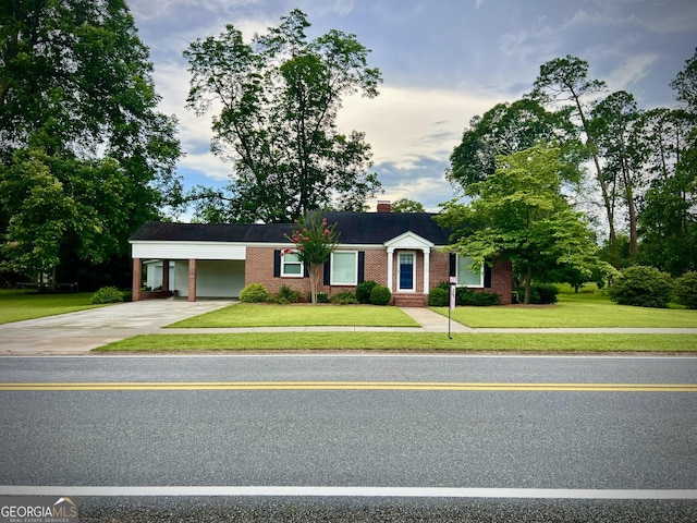 319 N Line St, Dexter, GA 31019 - ranch-style house with driveway, brick siding, a front yard, an attached carport, and a chimney