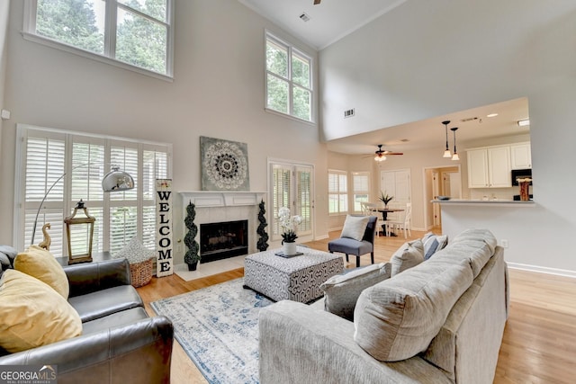 1868 Birch Briar Bnd, Lawrenceville, GA 30043 - living room with high vaulted ceiling, ceiling fan, a tile fireplace, and light wood-type flooring