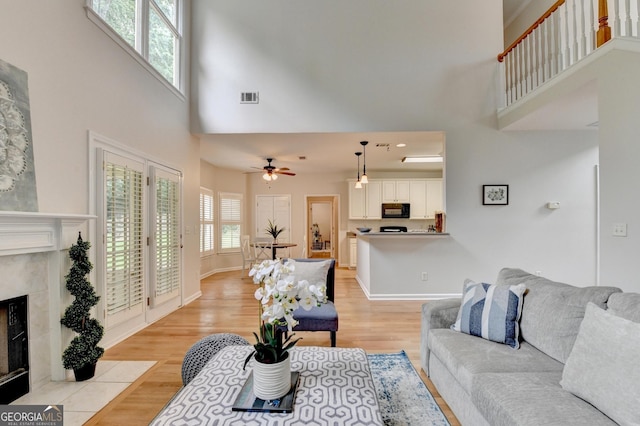 1868 Birch Briar Bnd, Lawrenceville, GA 30043 - living area featuring a high ceiling, light wood-type flooring, a high end fireplace, and a ceiling fan