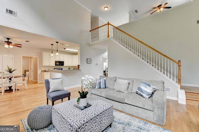 1868 Birch Briar Bnd, Lawrenceville, GA 30043 - living room with ceiling fan, light wood finished floors, stairs, and a towering ceiling