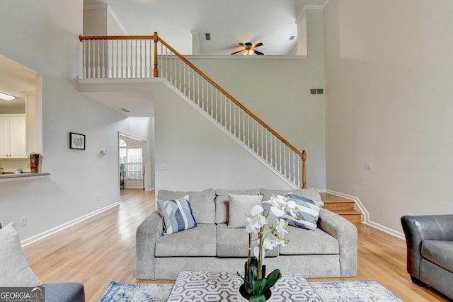 1868 Birch Briar Bnd, Lawrenceville, GA 30043 - living room featuring ceiling fan, stairs, light wood-style floors, and a towering ceiling