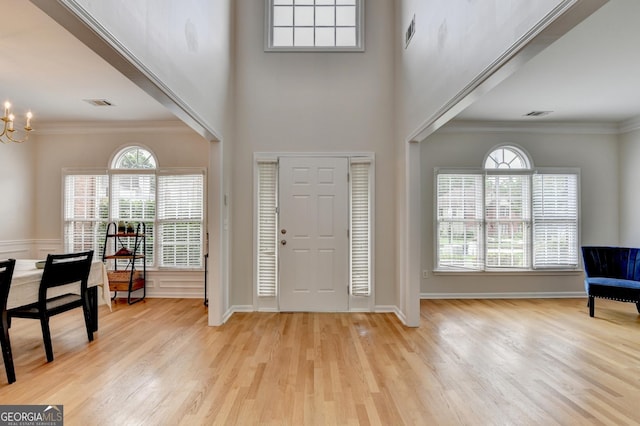 1868 Birch Briar Bnd, Lawrenceville, GA 30043 - entryway featuring wood finished floors, a chandelier, crown molding, and a towering ceiling