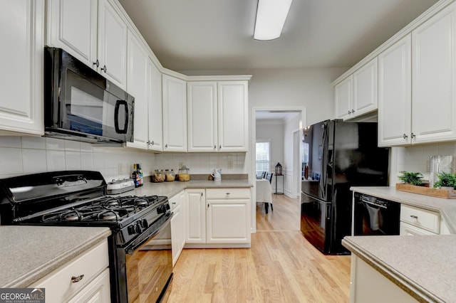 1868 Birch Briar Bnd, Lawrenceville, GA 30043 - kitchen with black appliances, light wood-style flooring, white cabinets, and backsplash