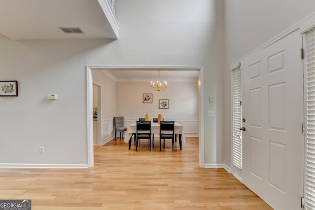 1868 Birch Briar Bnd, Lawrenceville, GA 30043 - foyer entrance with a chandelier, light wood finished floors, ornamental molding, and wainscoting