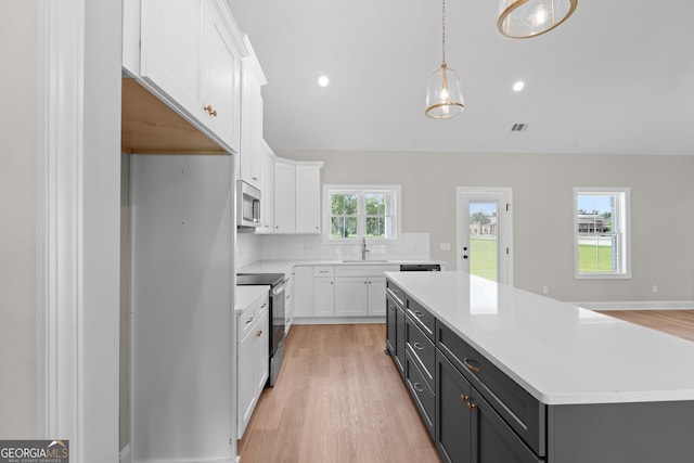 3 Honeysuckle Dr, Claxton, GA 30417 - kitchen featuring stainless steel appliances, white cabinets, a center island, light wood-type flooring, and recessed lighting