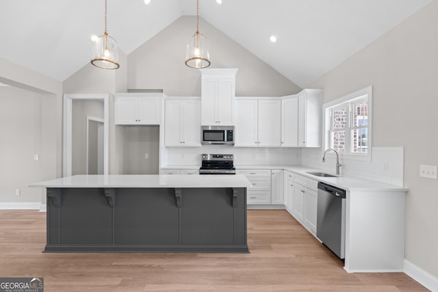3 Honeysuckle Dr, Claxton, GA 30417 - kitchen with appliances with stainless steel finishes, high vaulted ceiling, white cabinetry, light countertops, and a kitchen island