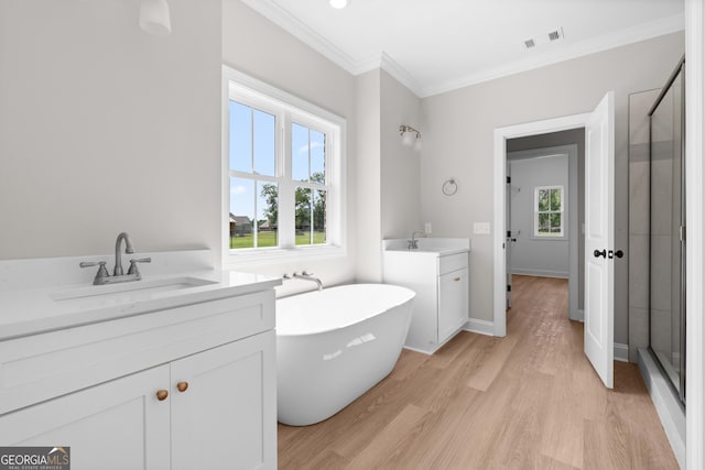 3 Honeysuckle Dr, Claxton, GA 30417 - full bath featuring two vanities, a stall shower, a freestanding bath, ornamental molding, and wood finished floors