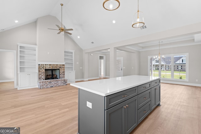 3 Honeysuckle Dr, Claxton, GA 30417 - kitchen featuring gray cabinetry, light wood finished floors, a ceiling fan, a kitchen island, and high vaulted ceiling