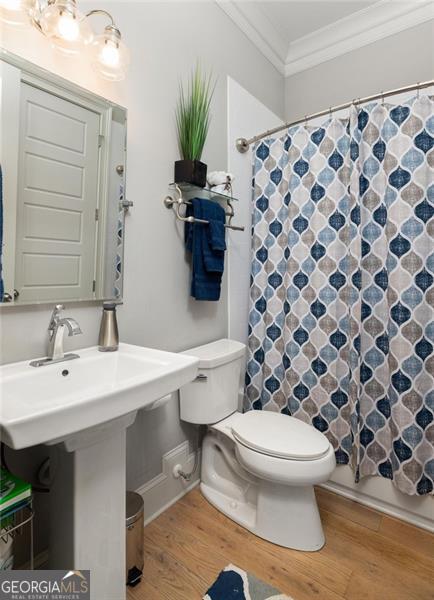 127 Oak Ln, Decatur, GA 30030 - bathroom with wood finished floors, ornamental molding, and a shower with curtain