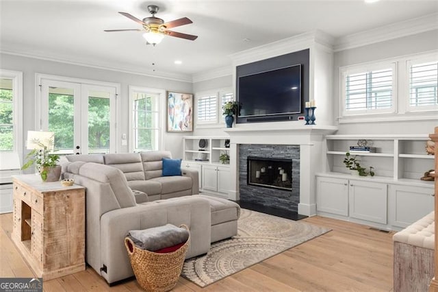 127 Oak Ln, Decatur, GA 30030 - living room featuring plenty of natural light, a ceiling fan, light wood-style flooring, a fireplace with flush hearth, and ornamental molding